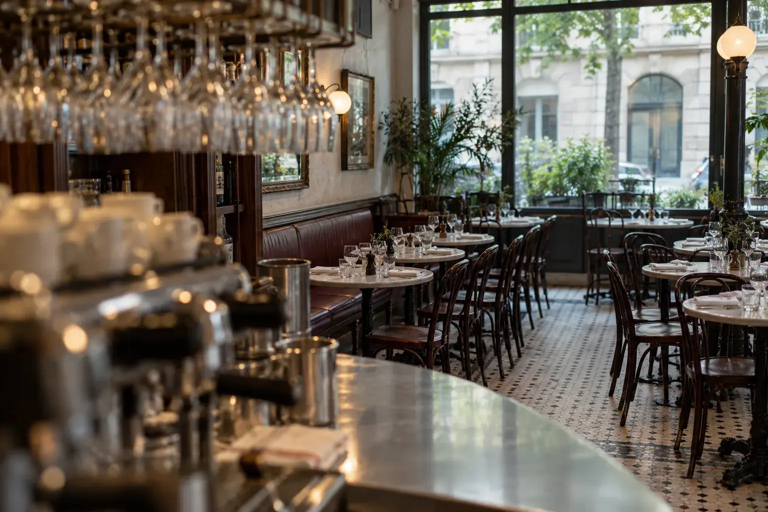 Salle de bistro avant l’ouverture, tables rondes dressées.